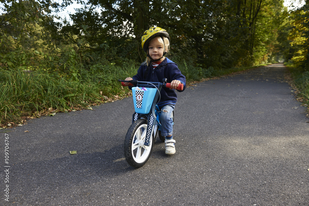 cute little girl riding runbike in summer
cute little girl riding runbike in summer