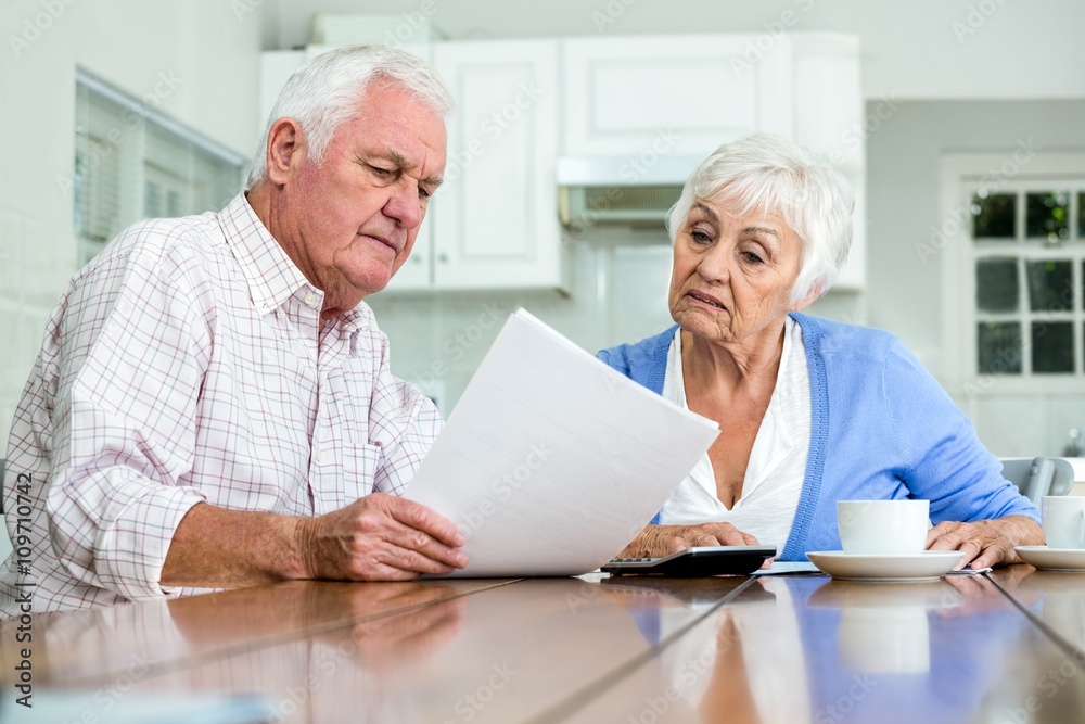 Happy couple with documents while sitting at table Happy couple with documents while sitting at table