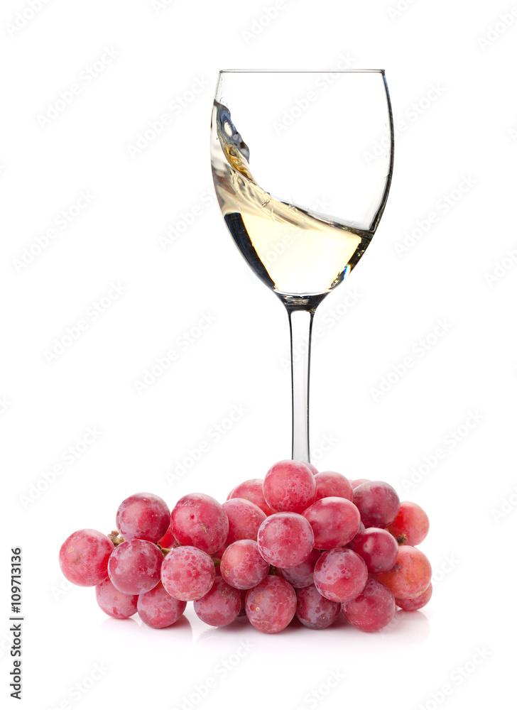 Splashing white wine in a glass and grapes Splashing white wine in a glass and grapes