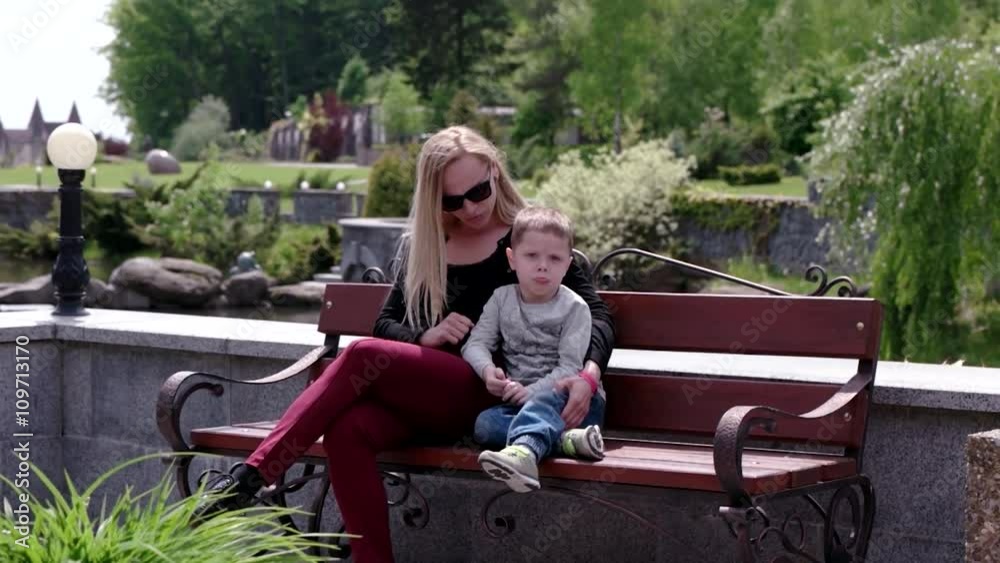 Mother and Son Sit on the Branch in Park Mother and Son Sit on the Branch in Park