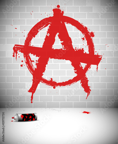 Red anarchy sign graffiti on brick wall