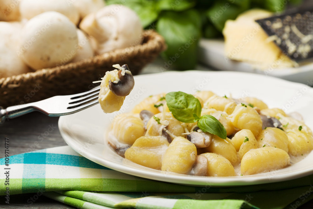 Portion of gnocchi with mushroom sauce and cheese.