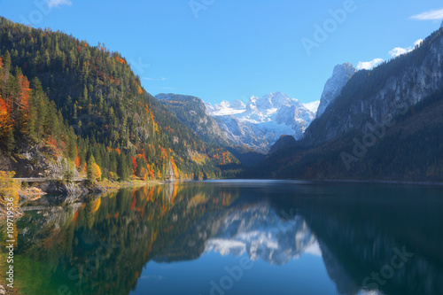 Autumn scenery of Lake Gosausee with snow-capped Dachstein Mountain in the background and beautiful reflections on the smooth water  in Gosau  Austria   A brisk fall scenery of Alps  Europe.