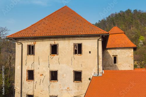 Upper floors of an old house with red tiled roof, no windows and ceiling. photo