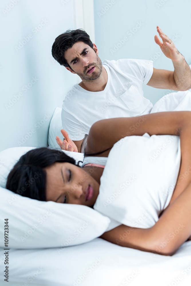 Young couple arguing on bed in bedroom Young couple arguing on bed in bedroom