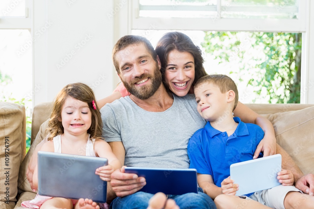 Parents with their kids using laptop and digital tablet