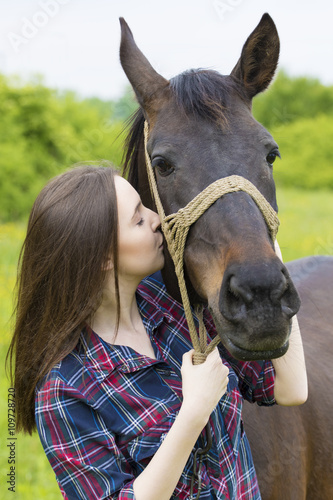 Teenager girl kiss the horse