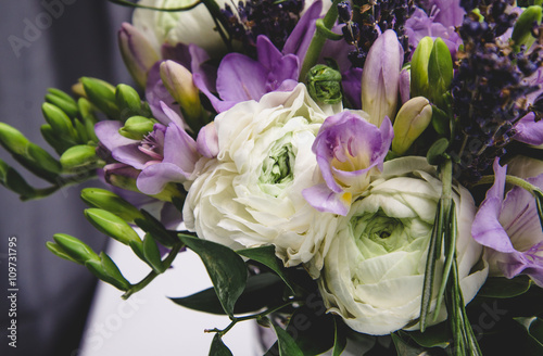 Beautiful spring wedding flowers white, violet, green buttercup ranunculus, fresia, lavender. Background soft macro. Rustic style, still life. Holiday floristic.