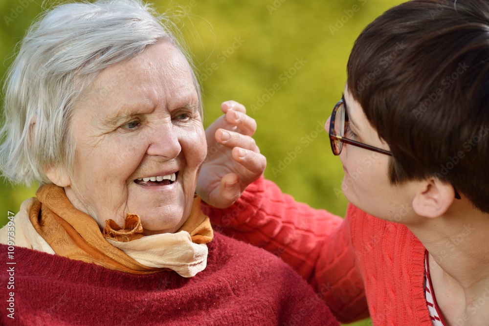 Grandmother and granddaughter. Young woman carefully takes care