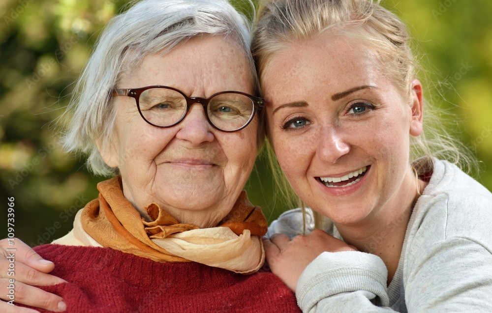 Grandmother and granddaughter. Young woman carefully takes care