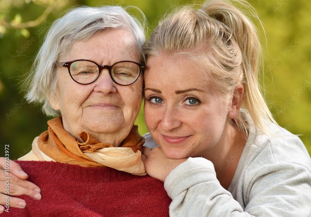 Grandmother and granddaughter. Young woman carefully takes care