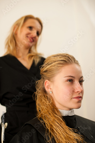 Hair stylist at work - hairdresser and customer evaluating hai