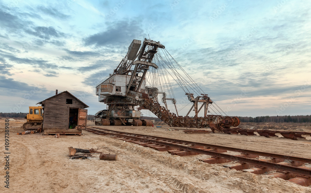 Many buckets of giant career excavator Equipment for the extraction of sand from the quarry. Dredge near the old railway track Many buckets of giant career excavator Equipment for the extraction of sand from the quarry. Dredge near the old railway track