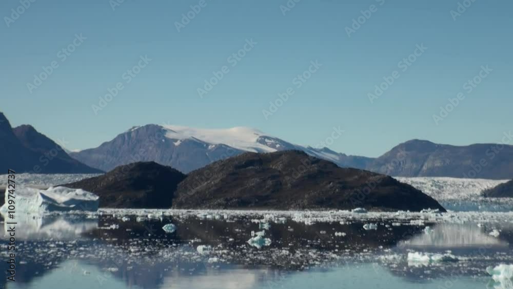Sea mountains and large icebergs reflecting in the water.  Fantastic wonderful amazing video grennlandii nature iceland. Lovely shooting the life of nature, seaside and mountains.