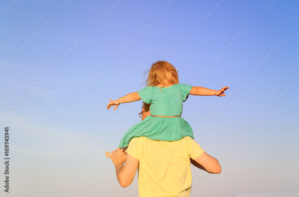 father and little daughter on shoulders play at sky father and little daughter on shoulders play at sky