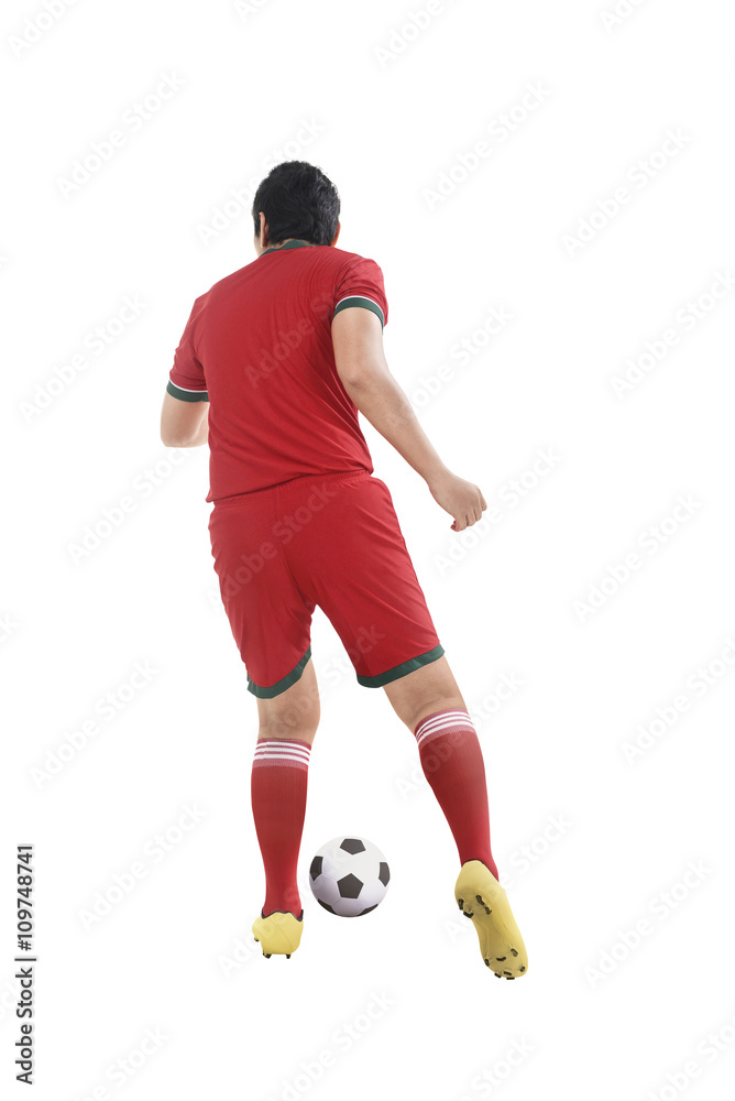 Back view of asian football player kick ball