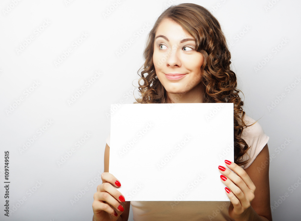 Smiling young casual style woman showing blank signboard Smiling young casual style woman showing blank signboard