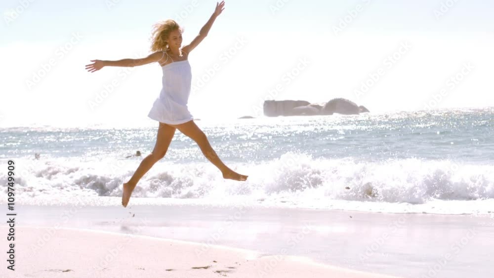 A woman is jumping with her white clothes A woman is jumping with her white clothes