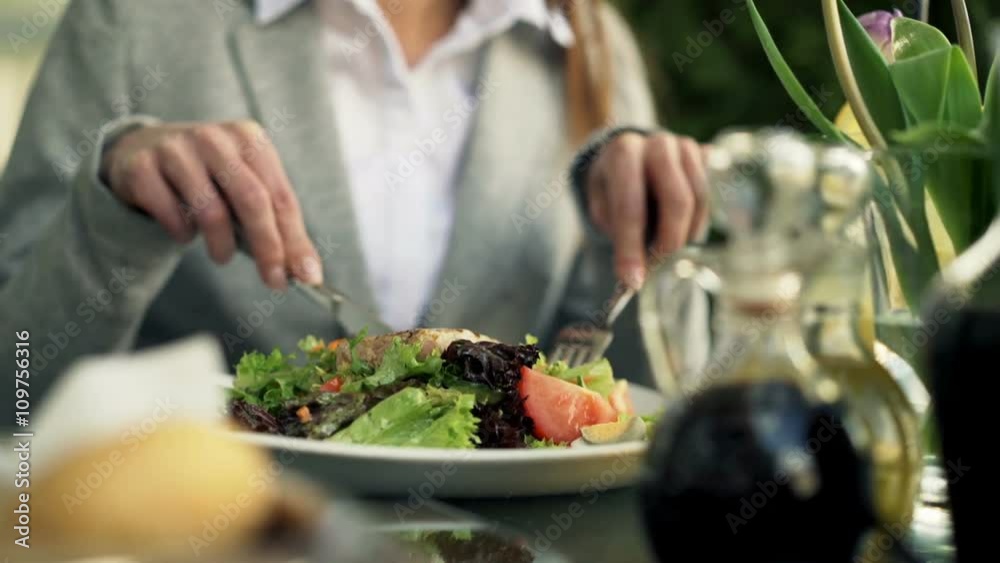 Woman eating salad sitting in cafe in city
Woman eating salad sitting in cafe in city