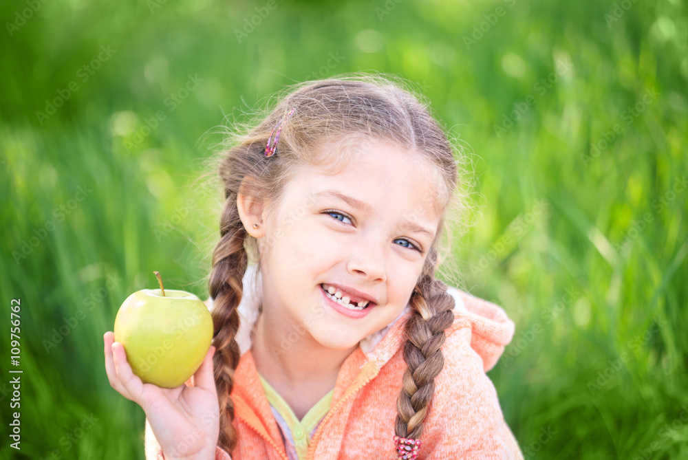 Sweet girl with a fallen toth holding an apple in her hand Sweet girl with a fallen toth holding an apple in her hand