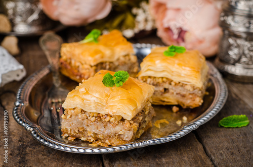 Walnuts baklava in oriental tray on wooden background. East sweets. Ramadan food. Selective focus © tanchy25