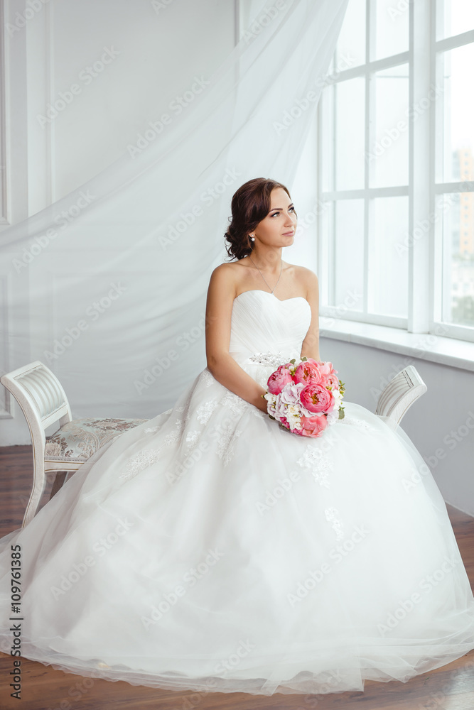 The Bride. Young women with wedding dress in very bright room, The Bride. Young women with wedding dress in very bright room,