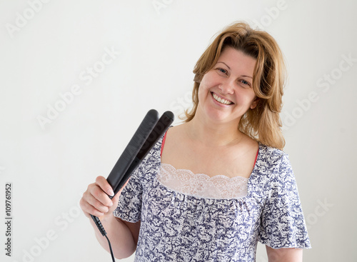 positive woman with curling tongs