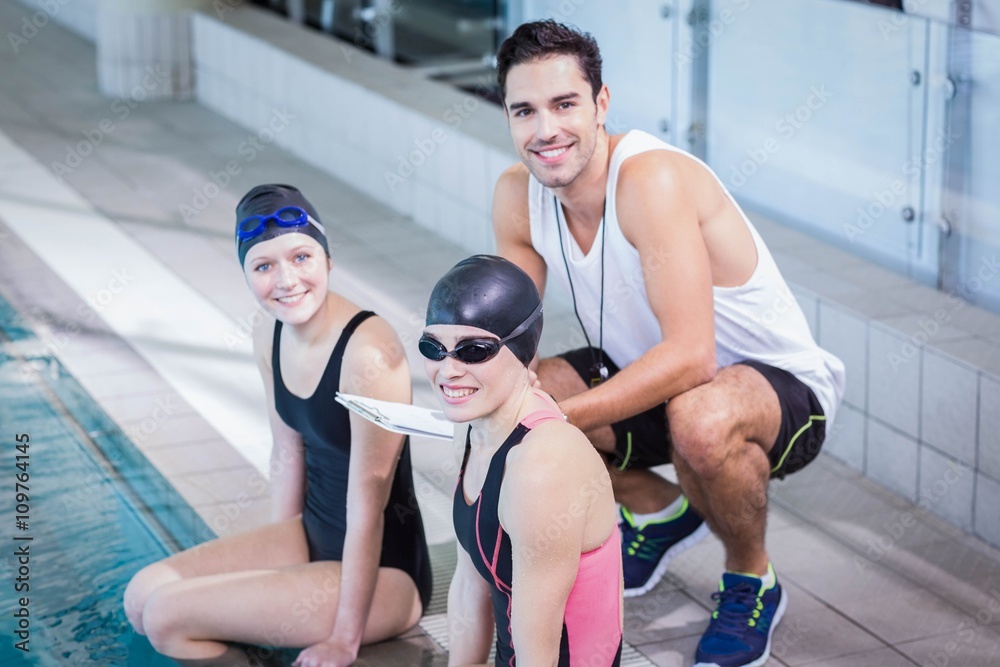 Trainer and swimmers smiling at the camera
