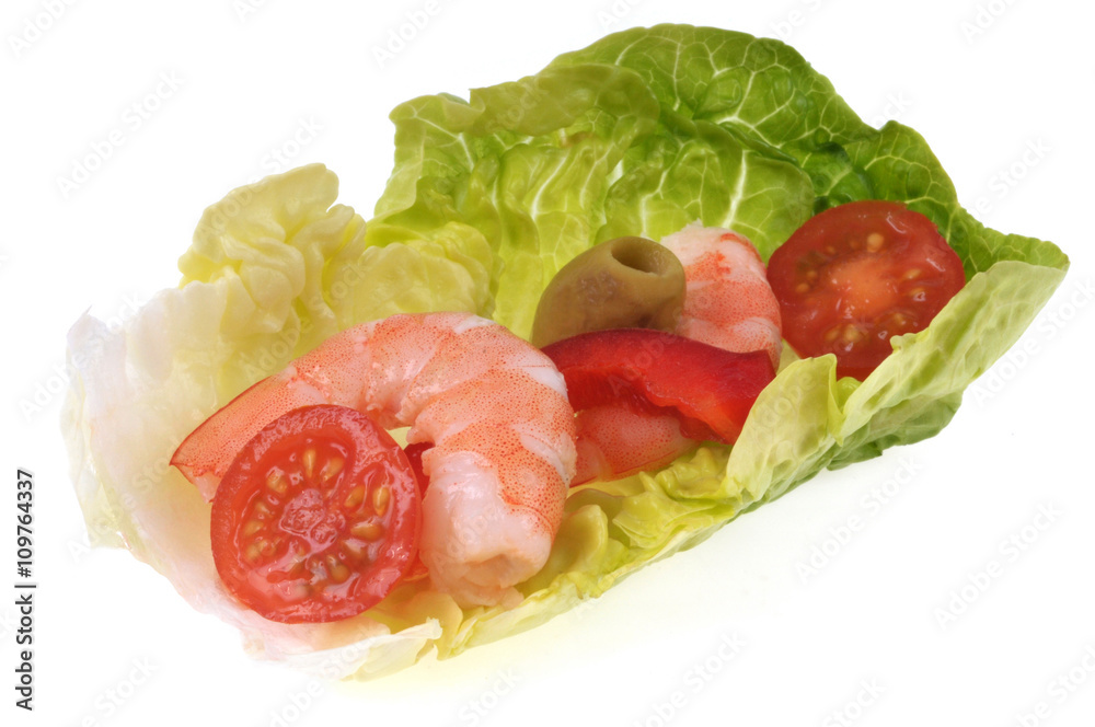 Amuse-bouche sur feuille de salade avec crevette, tomate cerise et olive