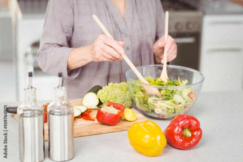 Midsection of woman preparing salad