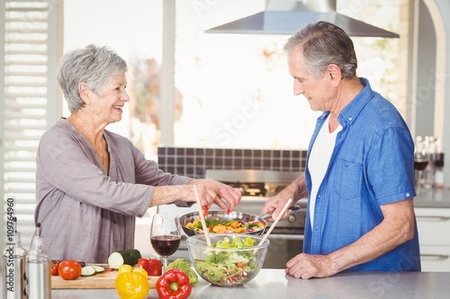 Side view of happy senior couple preparing food
