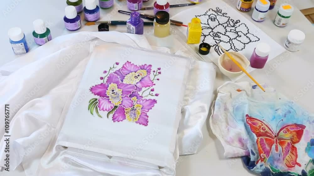 Batik Process: Artist paints on Fabric, Batik-making. Painter Draws the Floral motif on a Silk white Cloth. Handmade Beautiful Art Design. Artist Workshop with Tools, Paints and Brushes for Batik.
