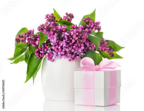 Lilac flowers in a white vase and gift box