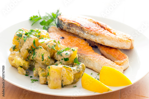 Salmon steak dinner with herbs and roasted potatoes