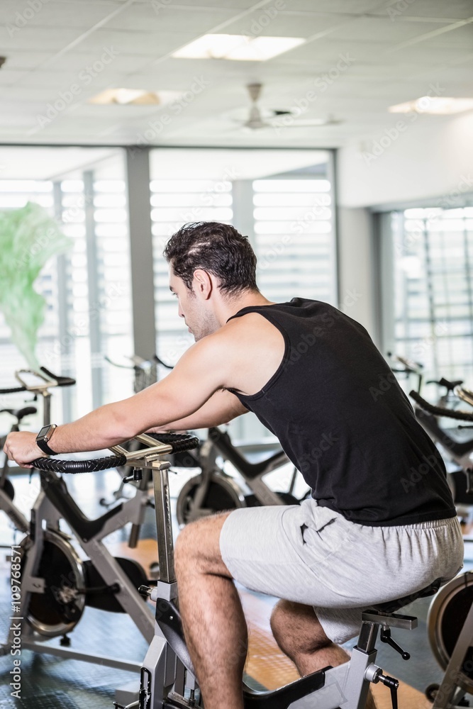 Focused man using exercise bike Focused man using exercise bike