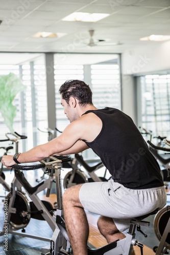 Focused man using exercise bike