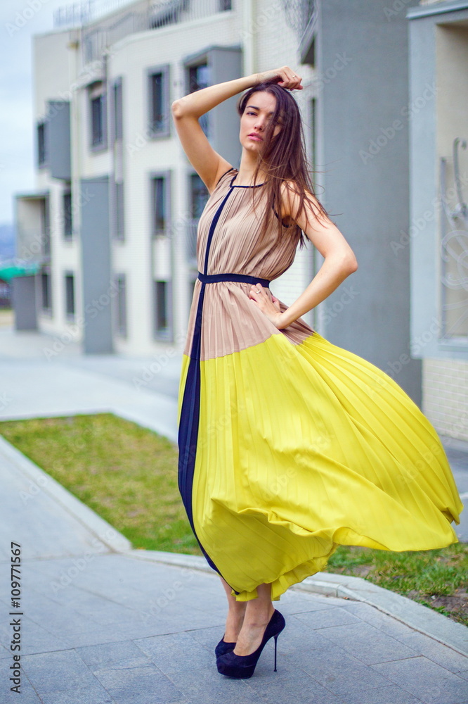 Beautiful brunette in a dress on the street. Beautiful brunette in a dress on the street.