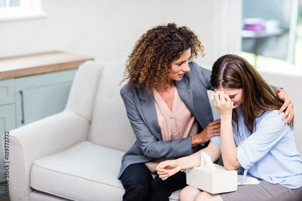 Psychologist consoling depressed woman at home Psychologist consoling depressed woman at home