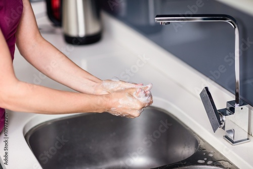 Cropped image of woman washing hands at sink