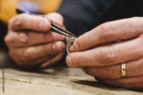 Close-up of a jeweler mounting a gemstone onto a ring