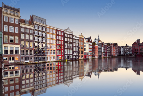 Row of traditional narrow colourful terraced houses reflected in a canal at sunset, Amsterdam, North Holland, Netherlands photo