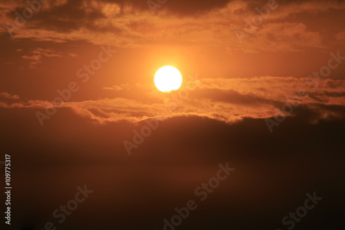 Fototapeta Naklejka Na Ścianę i Meble -  Orange sunset sky with a Sun and feather clouds