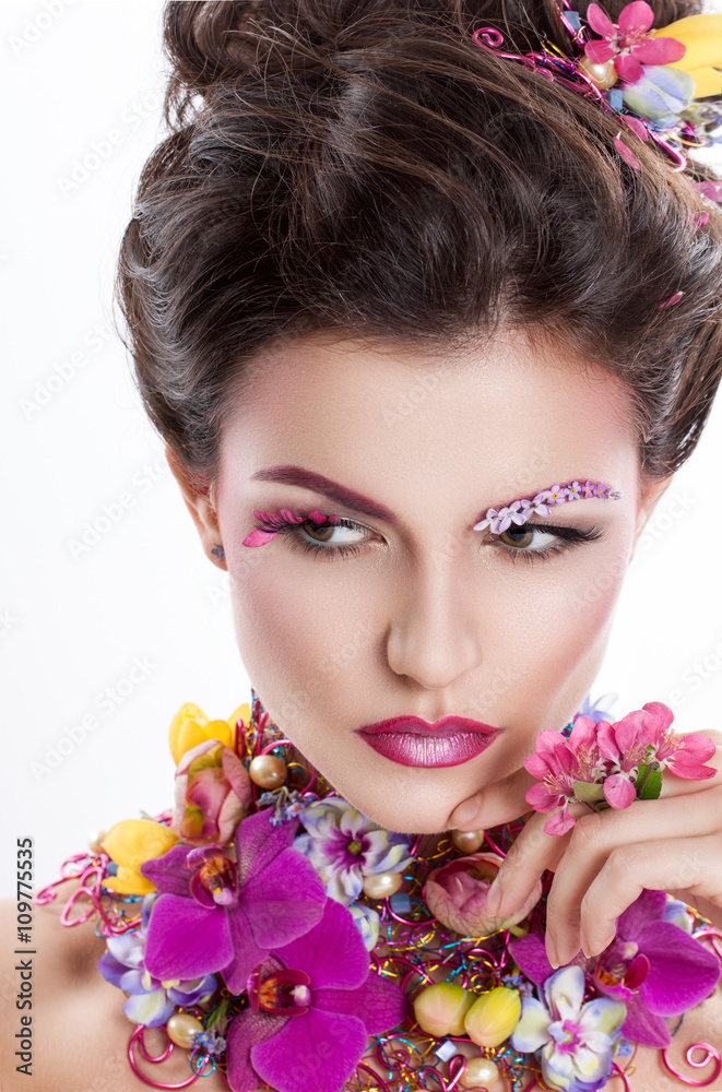 Fototapeta premium Fashion Beauty woman with flowers in her hair and around her neck. Perfect Creative Make up and Hair Style. Hairstyle. Bouquet of Beautiful Flowers. It can be used for advertising perfume