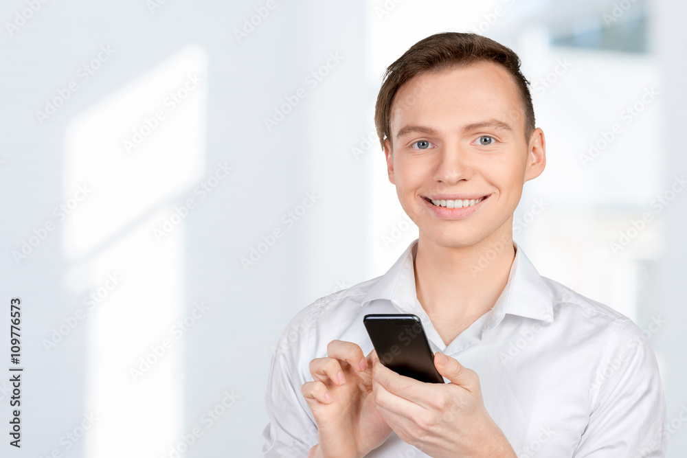 Young man typing text message on his cellphone Young man typing text message on his cellphone