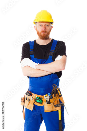 Young man builder with belt of construction tools