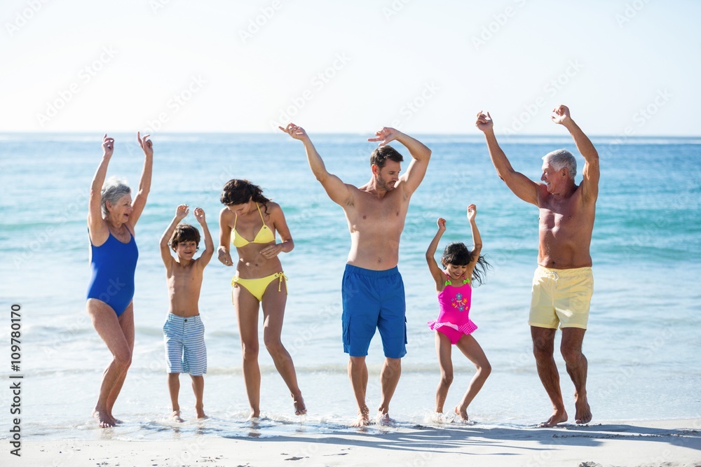 Happy family dancing on the beach