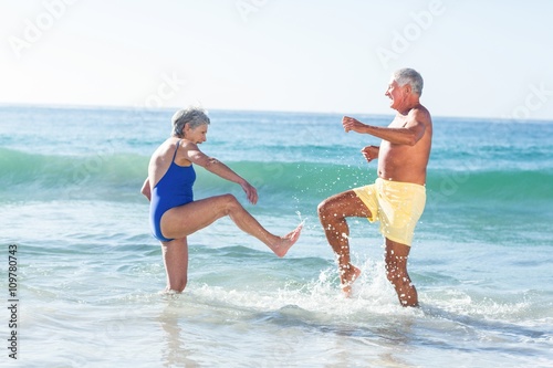 Senior couple playing with waves