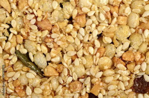 sesame, sunflowers and other seeds with dried fruits as background.