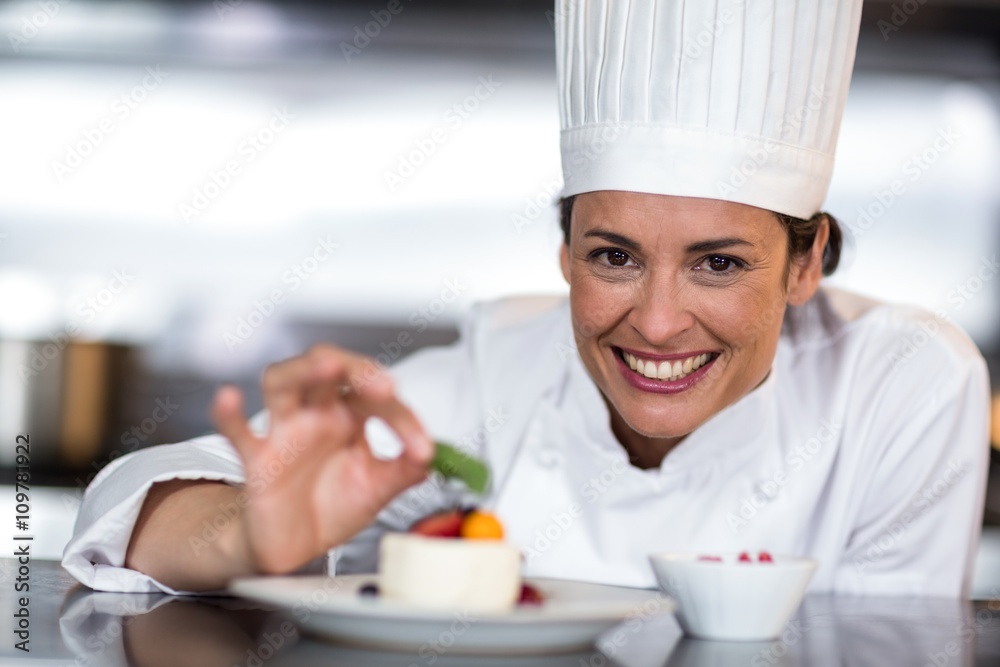 Portrait of happy female chef garnishing on food Portrait of happy female chef garnishing on food