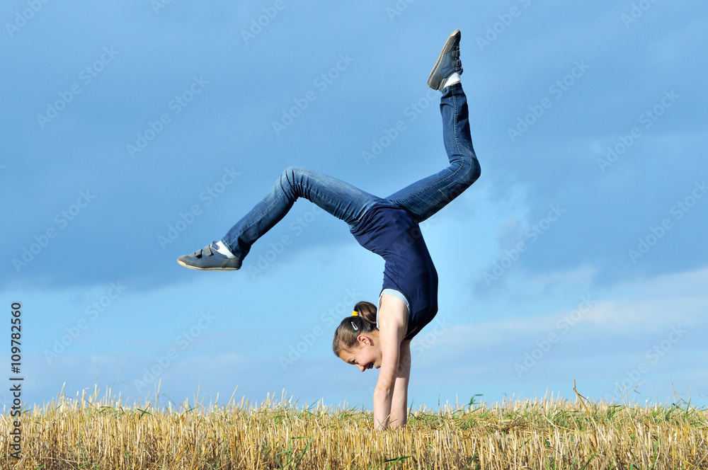 beautiful girl doing a handstand in a meadow beautiful girl doing a handstand in a meadow